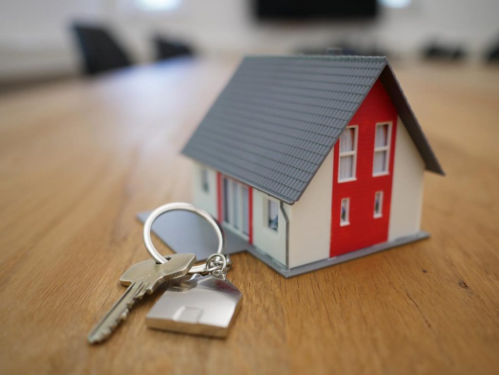 Una maqueta de una casa junto a una llave